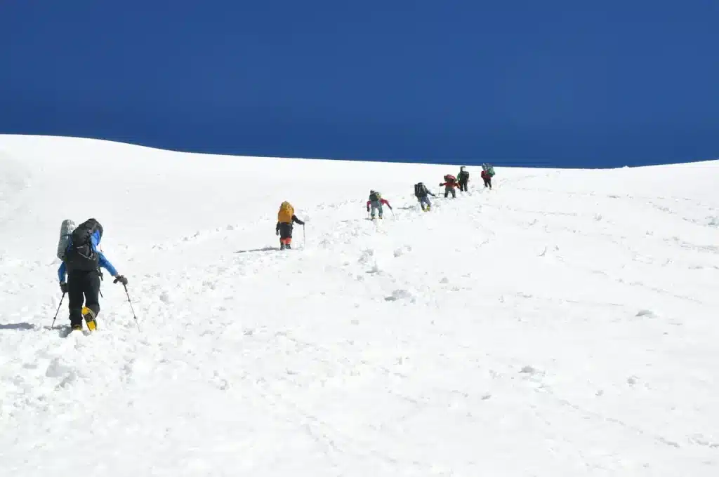 A Group of People Hiking Up a Snowy Mountain