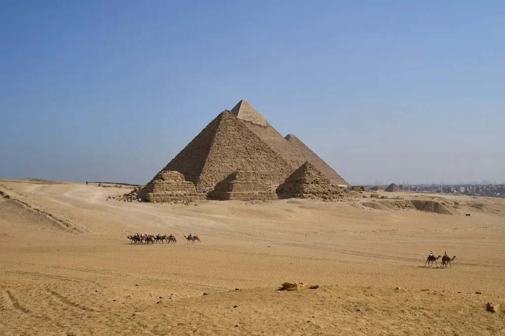 A Group of People Riding Camels in Front of a Pyramid