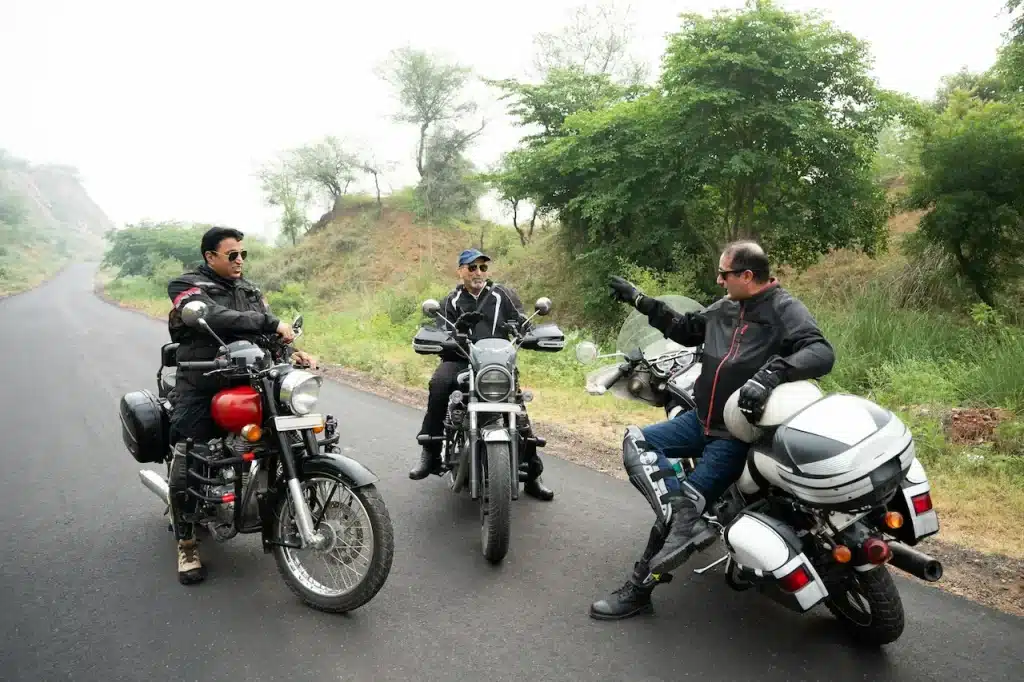 Three Motorcyclists Pose on the Road