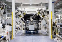 High-tech robots assembling a car in a modern factory setting showcasing automation.