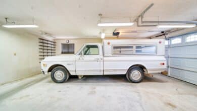 A white truck parked in a garage next to a garage door