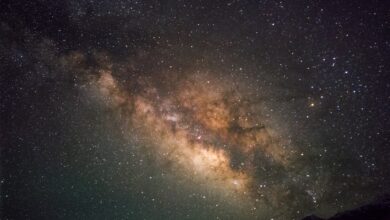 a starry night sky with a mountain and a mountain