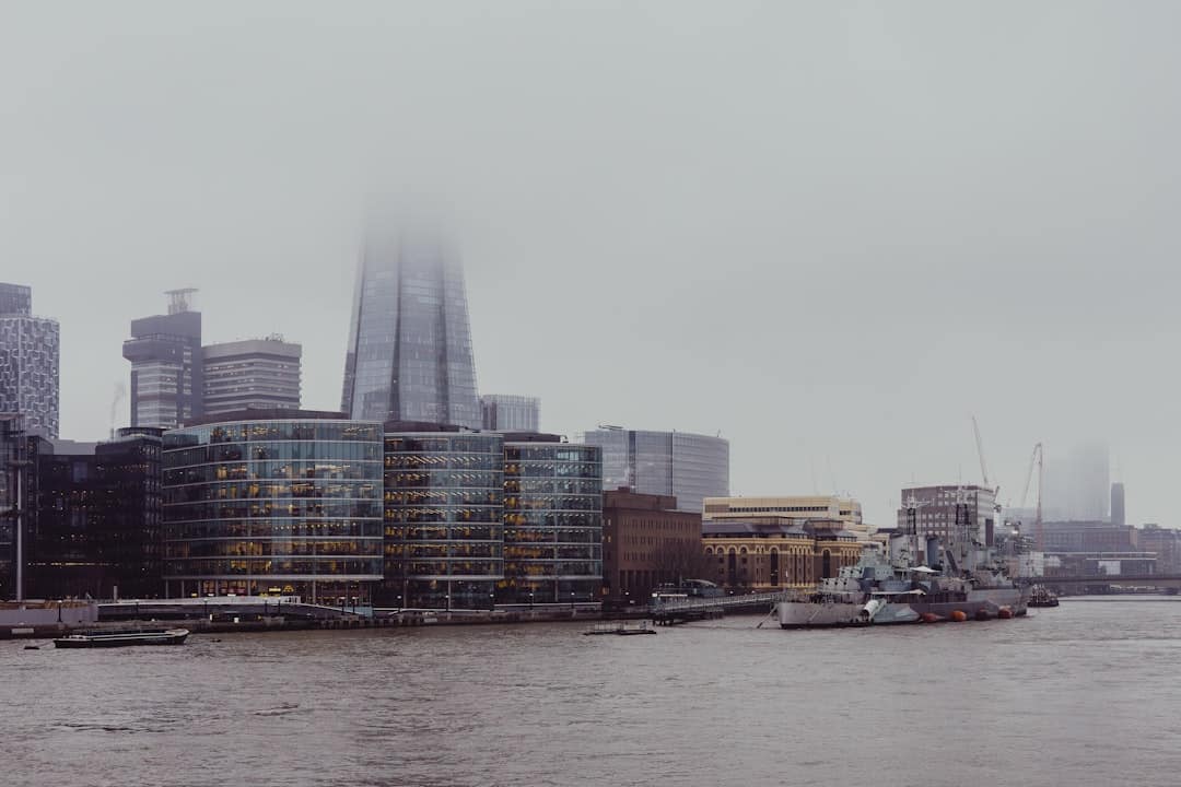 Foggy city skyline with modern buildings and river.