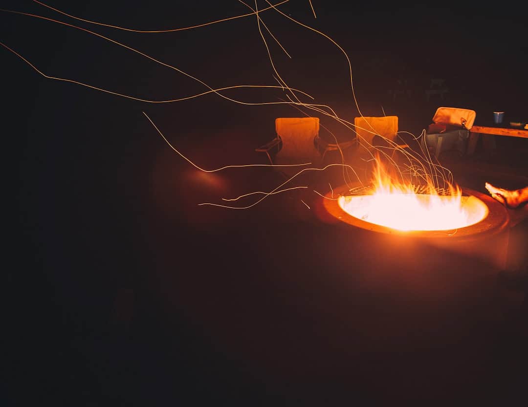 a fire pit with a person holding a lit candle