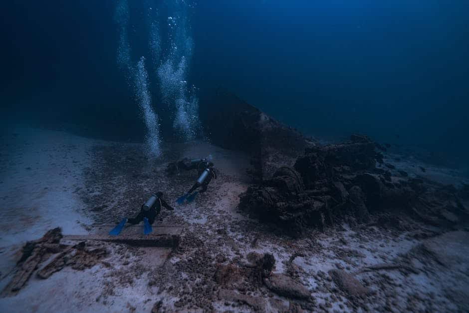 Two scuba divers explore an underwater shipwreck off the coast of Isla Mujeres Mexico.