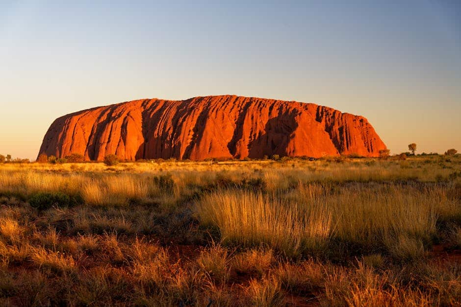 Stunning view of Uluru Australia's iconic rock formation at sunrise in the Outback.