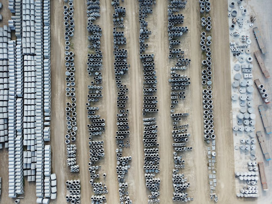 Drone shot of an organized outdoor concrete manufacturing facility with various pipes.